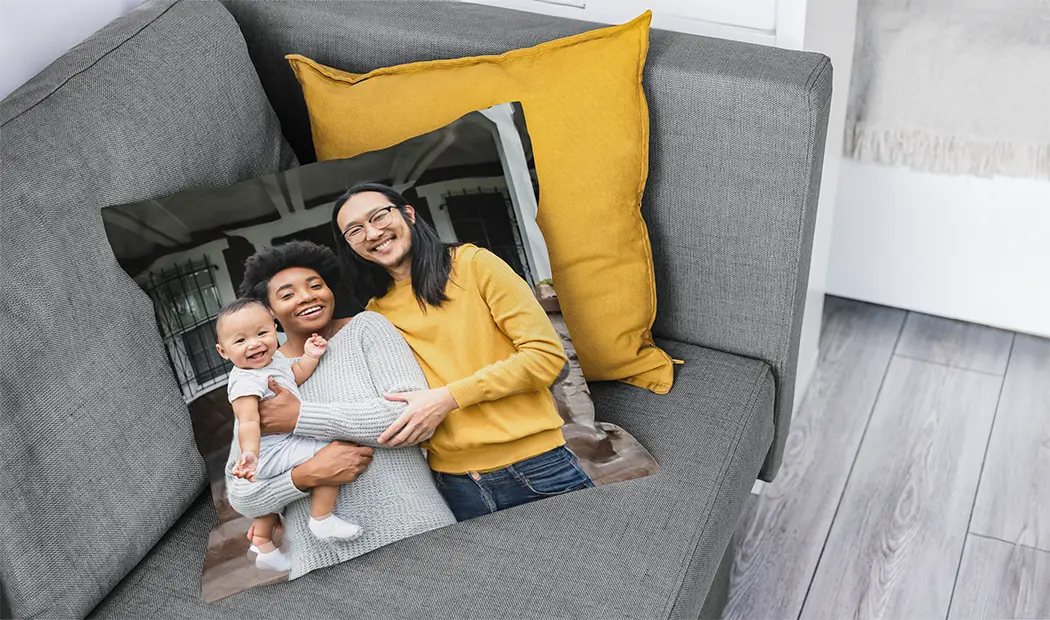 Personalised cushion featuring a happy family photo, placed on a sofa.  Create a unique keepsake!