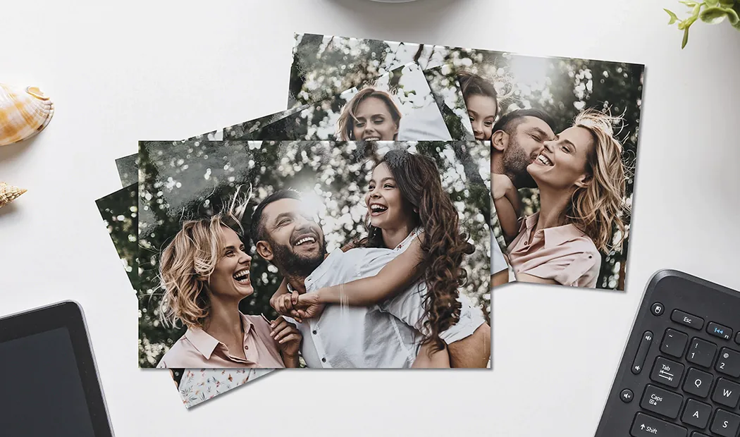 Hands holding a photo print of three kids on holiday